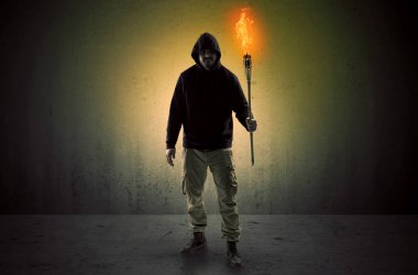 Boş bir alanda flambeau yanma ile yürüyen adam