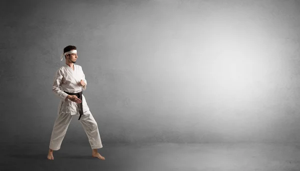 Kleiner Karate-Mann kämpft in einem leeren Raum — Stockfoto