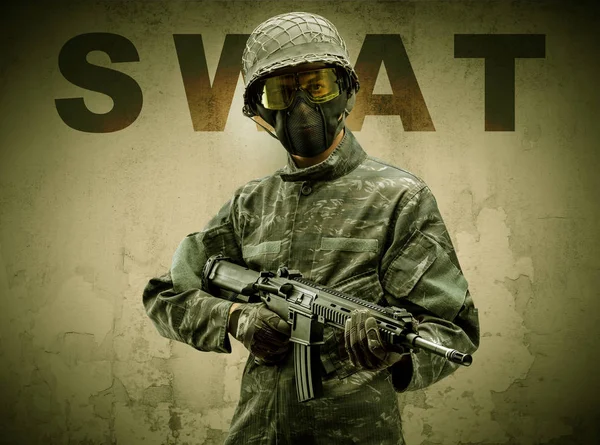 Soldat armé avec fond mural endommagé — Photo