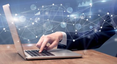 El laptop ile bağlantılı bir rapor ve grafikler çevresinde yazarak