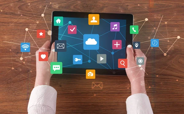 Hand mit Multitasking-Tablet mit Anwendungssymbolen und Symbolen Konzept — Stockfoto
