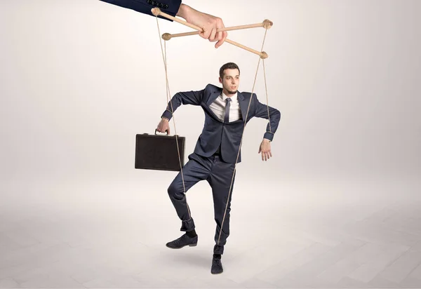 Puppet businessman leaded by a huge hand — Stock Photo, Image