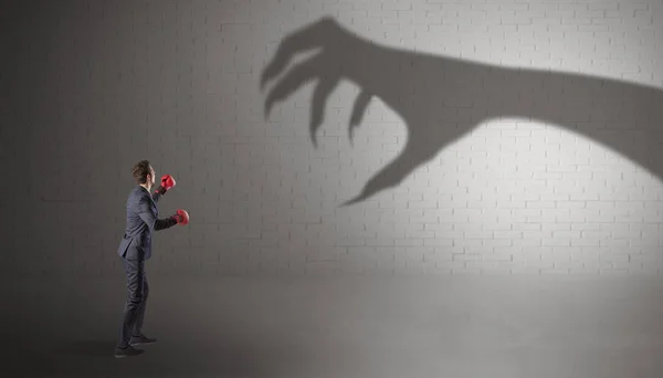Empresario luchando con espantosa sombra de manos — Foto de Stock
