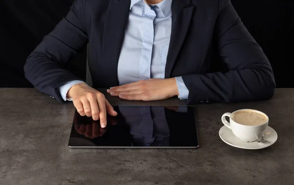 Business woman working on tablet with dark background