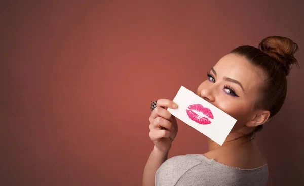 Pessoa sorrindo com um cartão na frente de sua boca — Fotografia de Stock