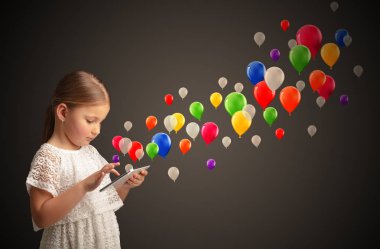 Kız holding tablet renkli balonlar ile