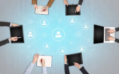 Dizüstü bilgisayarlar ve office konseptiyle tablet üzerinde çalışan bir grup ile aygıt içinde insan eller