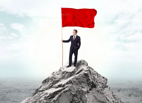 Empresario en la cima de una bandera de la montaña — Foto de Stock