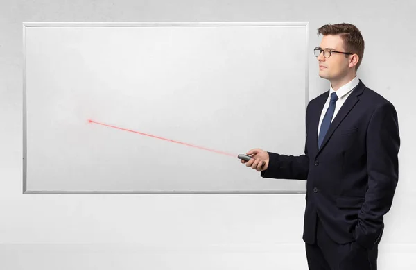 Businessman with laser pointer and copyspace white blackboard — Stock Photo, Image