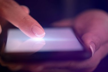 Koyu arka plan ile telefon dokunmak parmak