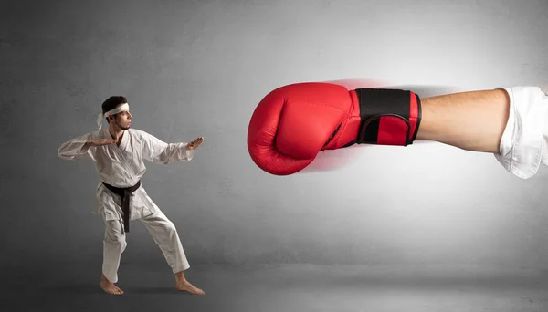 Pequeño hombre luchando con un gran guante de boxeo rojo — Foto de Stock