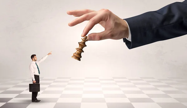 Affärsman som kämpar mot stora chessman på en stor hand — Stockfoto