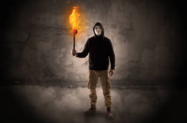 Wayfarer with burning torch in front of crumbly wall concept — Stock Photo, Image