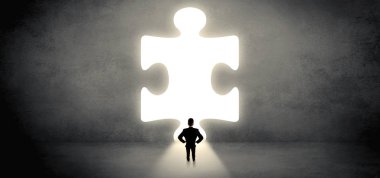 Bir büyük bulmaca parçası önünde duran işadamı
