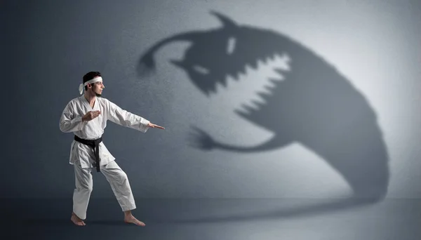 Karate man fighting with a big scary shadow