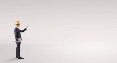 Boş bir alanda duran ve bir plan tutan mimar