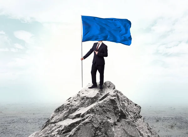 Empresario en la cima de una bandera de la montaña — Foto de Stock