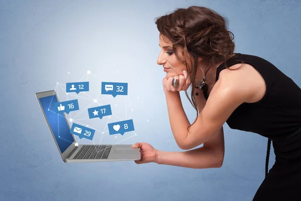 Woma segurando laptop com notificações de mídia social — Fotografia de Stock