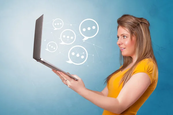 Woman holding laptop with speech bubbles — Stock Photo, Image