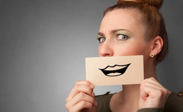Person holding in front of her mouth a card — Stock Photo, Image