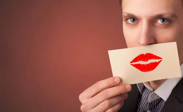 Persona sonriendo con una tarjeta delante de su boca — Foto de Stock