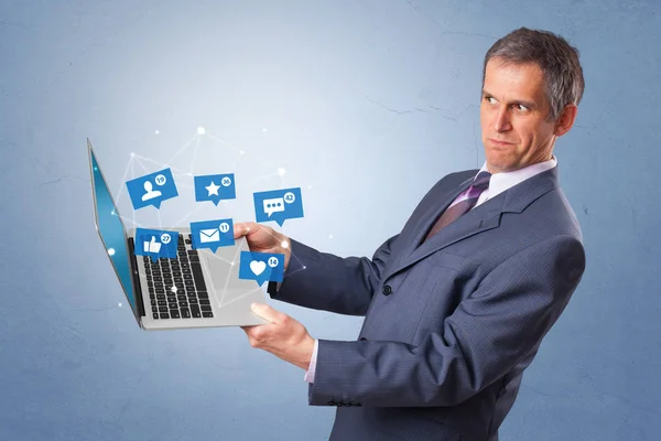 Man holding laptop with social media notifications — Stock Photo, Image