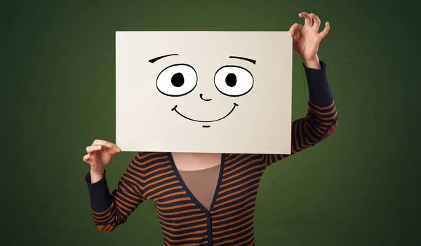 Student holding a paper with laughing emoticon in front of his face — Stock Photo, Image