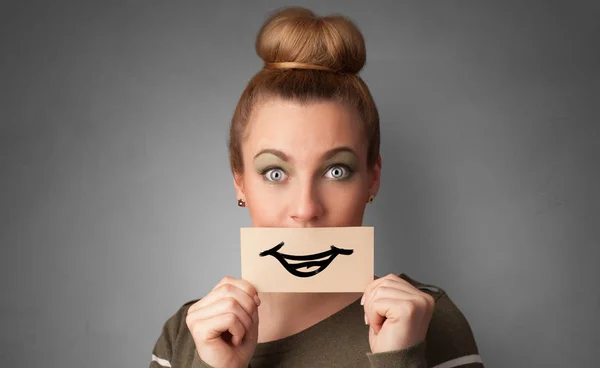 Persona sosteniendo delante de su boca una tarjeta — Foto de Stock