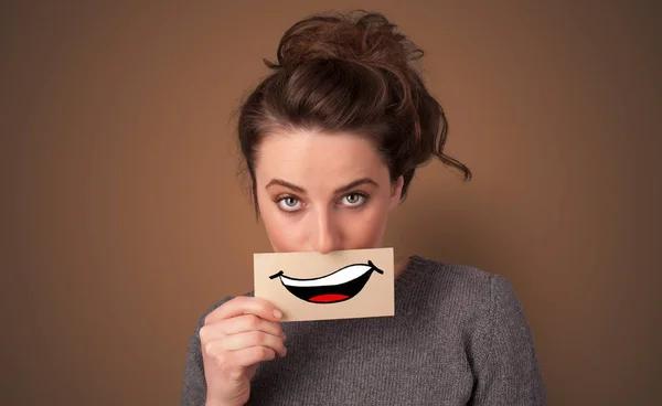 Pessoa segurando cartão na frente de sua boca — Fotografia de Stock