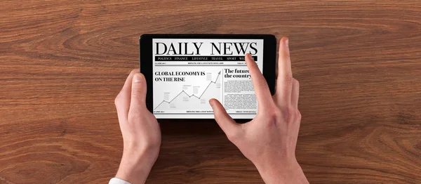 Hand with tablet reading news — Stock Photo, Image