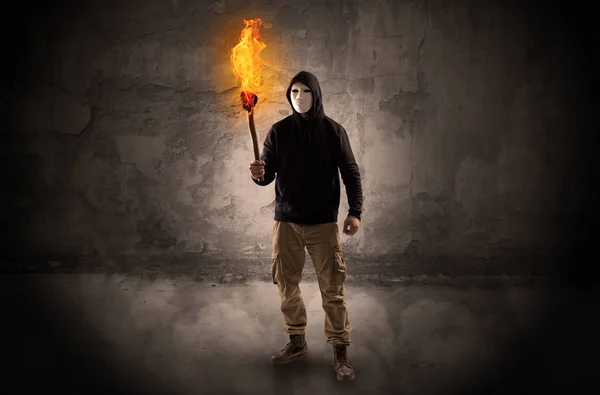 Wayfarer with burning torch in front of crumbly wall concept — Stock Photo, Image