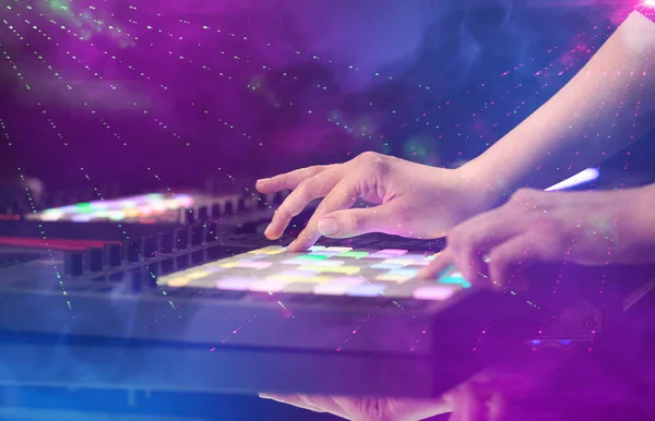 Mixing music on midi controller with party club colors around — Stock Photo, Image