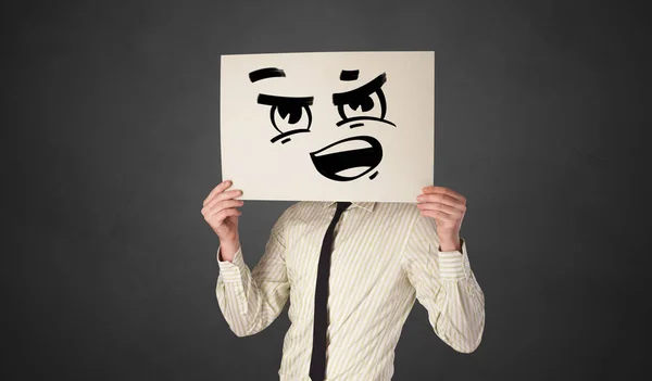 Person holding a paper with funny emoticon in front of her face — Stock Photo, Image