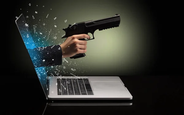 Hand with gun coming out of a laptop — Stock Photo, Image