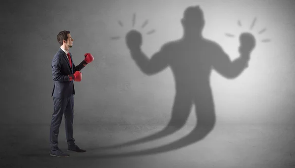 Businessman fighting with his unarmed shadow — Stock Photo, Image