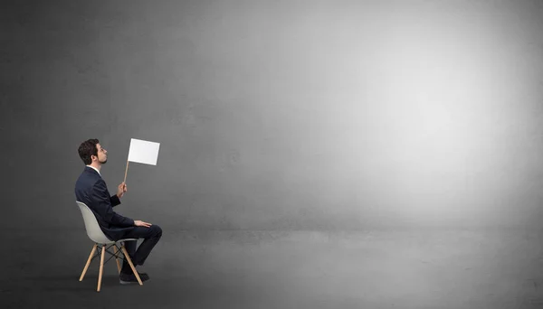 Businessman staying in an empty room with stuffs on his lap — Stock Photo, Image