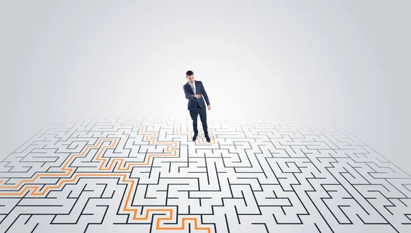 Jovem empreendedor em pé no meio de um labirinto — Fotografia de Stock