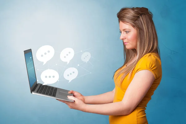 Woman holding laptop with speech bubbles — Stock Photo, Image