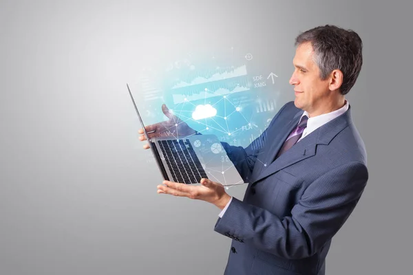 Homem segurando laptop com conceito de sistema baseado em nuvem — Fotografia de Stock