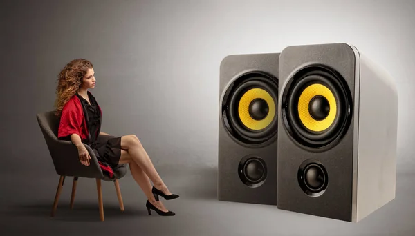 Young lady listening to big loudspeakers — Stock Photo, Image