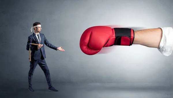 Маленький человек сражается в большой красной боксерской перчатке — стоковое фото