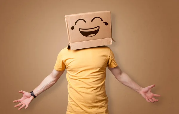 Homem engraçado sorrindo com cabeça de caixa de papelão — Fotografia de Stock