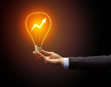 Koyu arkaplanda el ele tutuşan ampul