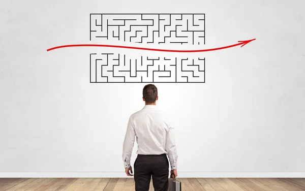 Businessman looking to a maze on a wall — Stock Photo, Image