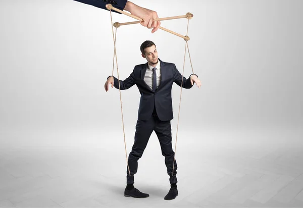 Marionet zakenman gelode door een enorme hand — Stockfoto
