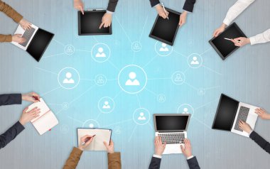 Dizüstü bilgisayarlar ve office konseptiyle tablet üzerinde çalışan bir grup ile aygıt içinde insan eller