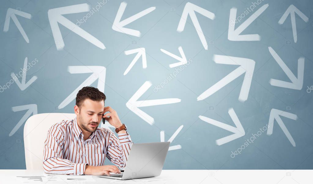 Business person sitting at desk with direction concept