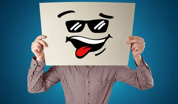 Persona sosteniendo un papel con cara de emoticono fresco — Foto de Stock