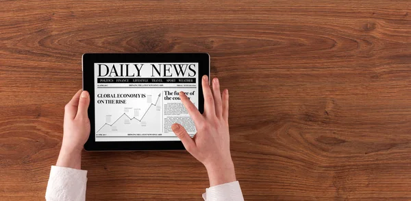 Hand with tablet reading news