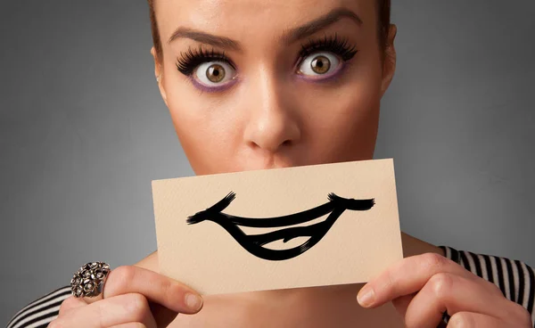 Person holding in front of her mouth a card — Stock Photo, Image
